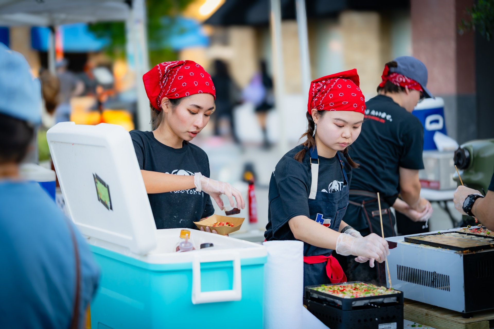 Crew cooking takoyaki on the griddle